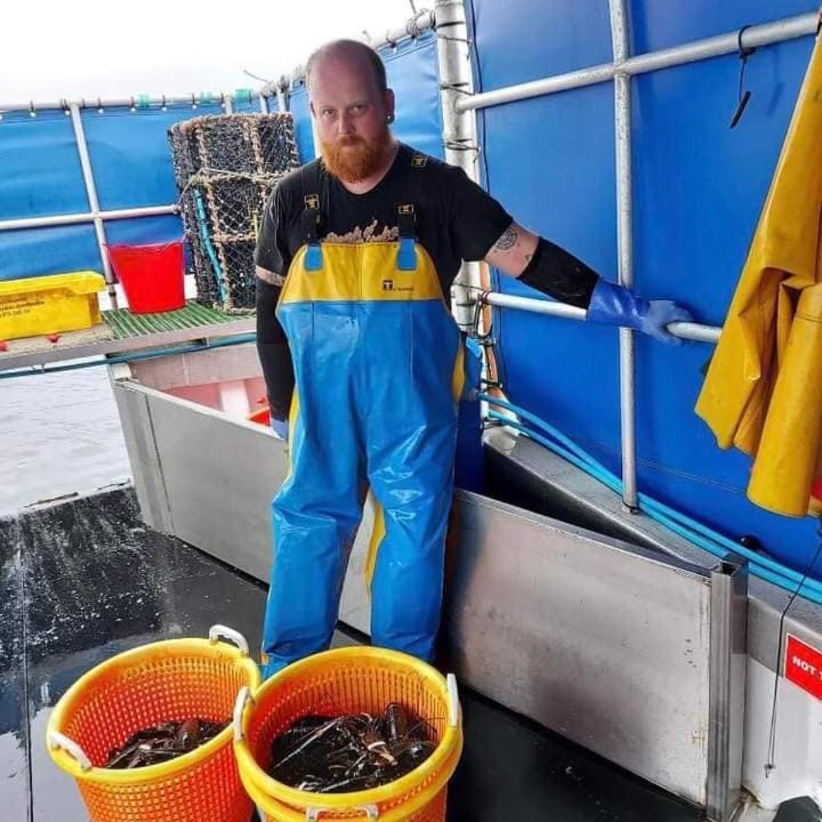 fisherman with two buckets of dead crustaceans